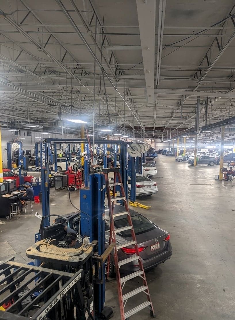Rows of two-post lifts across a full dealership service floor