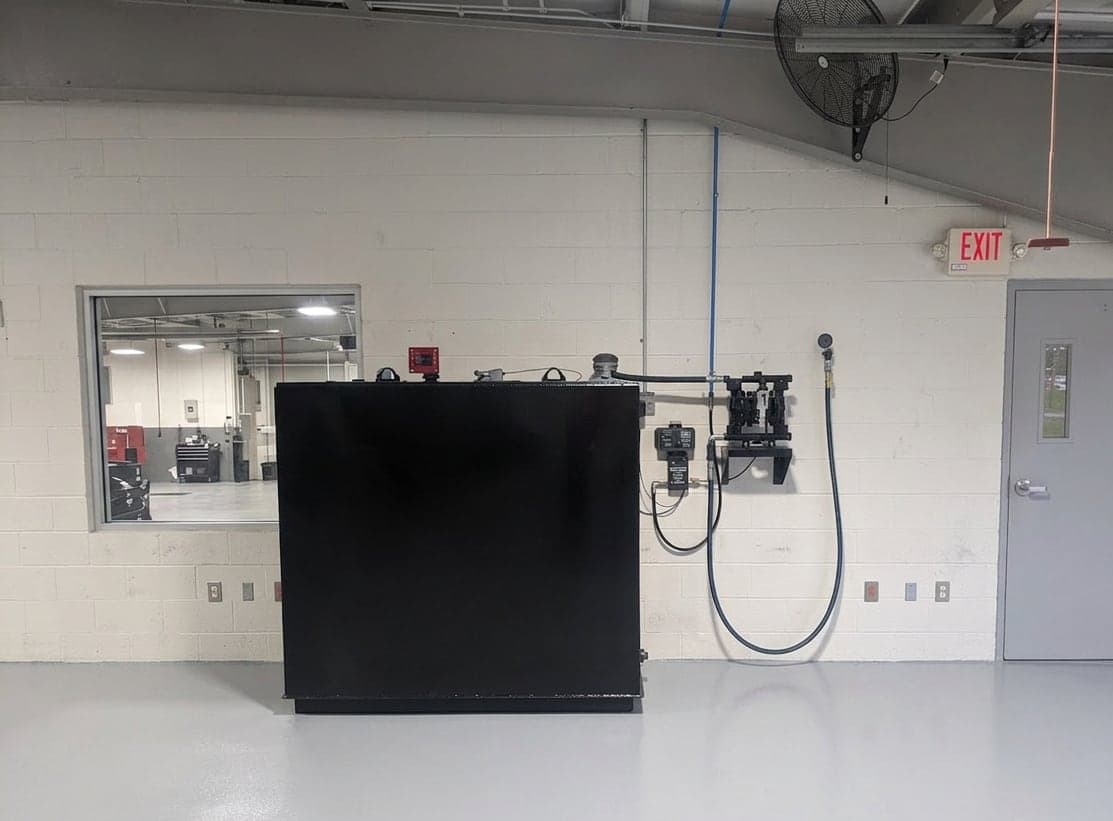 Bulk waste oil tank with diaphragm pump and hose reel plumbed on the wall